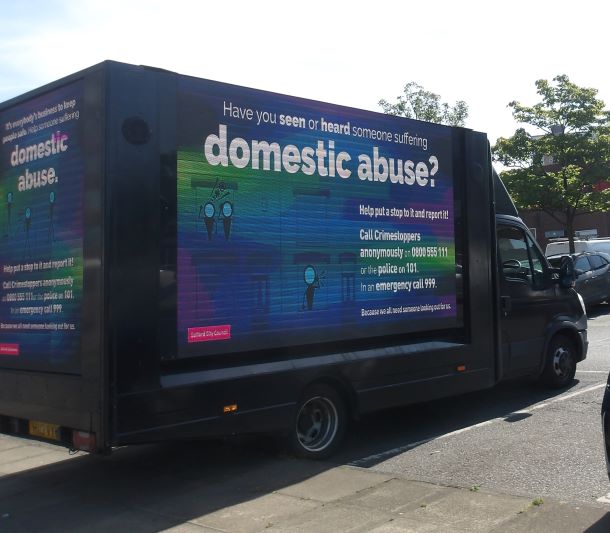 Van showing advert encouraging people to report domestic absue